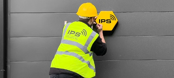 IPS engineer installing an intruder alarm box 